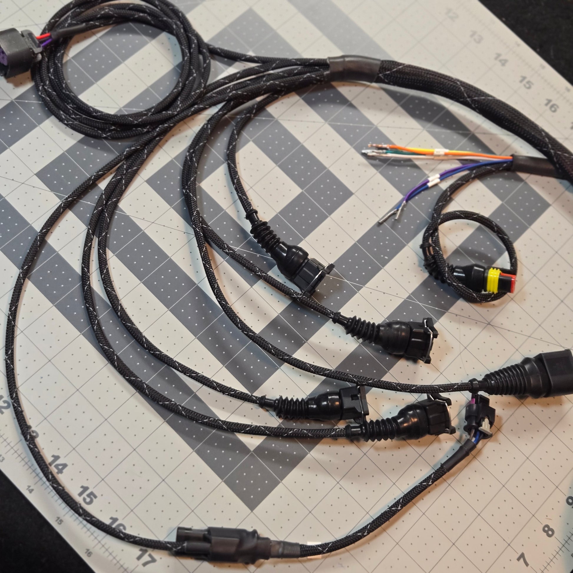 Set of black cables with connectors on a grid surface