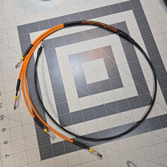 Coiled cable with orange and black wires on a grid background
